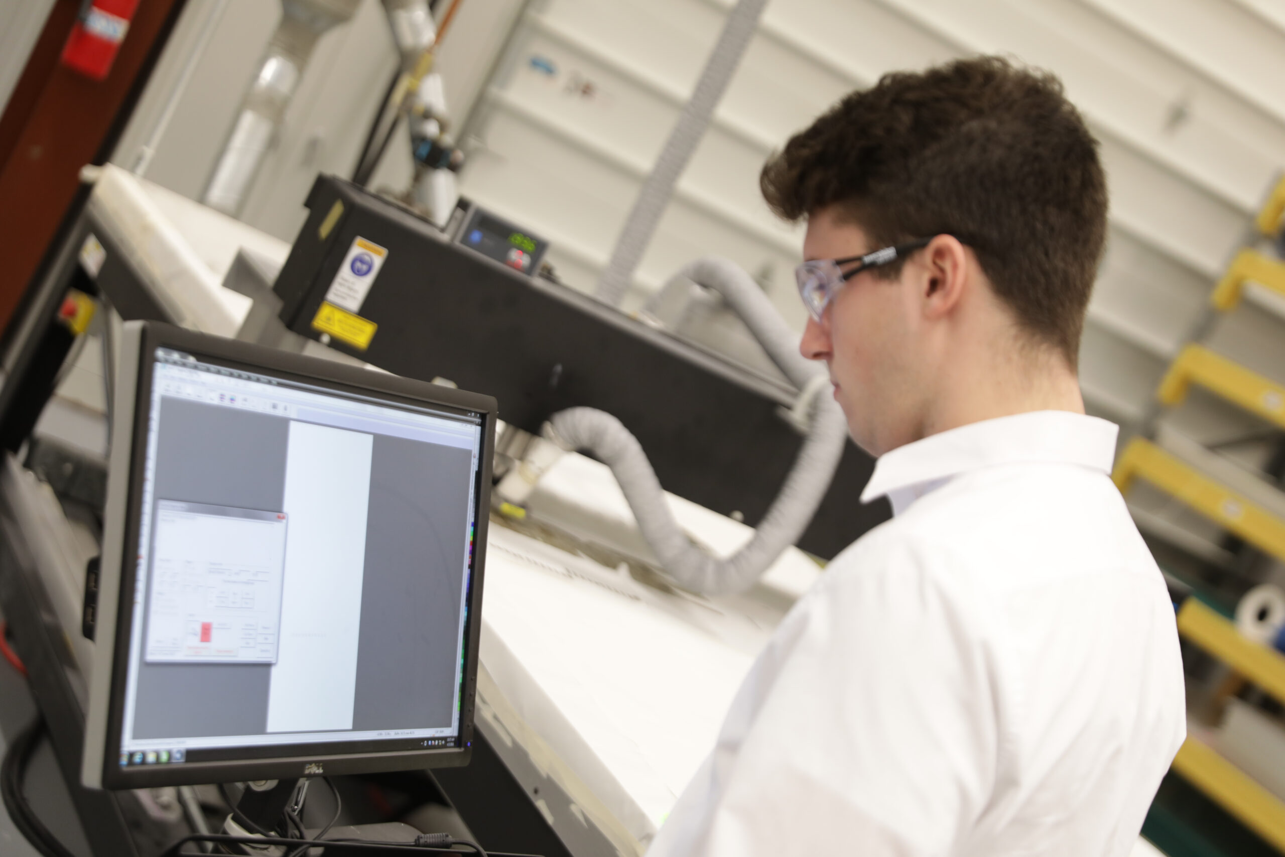 An engineer looks at a computer while developing a prototype process 