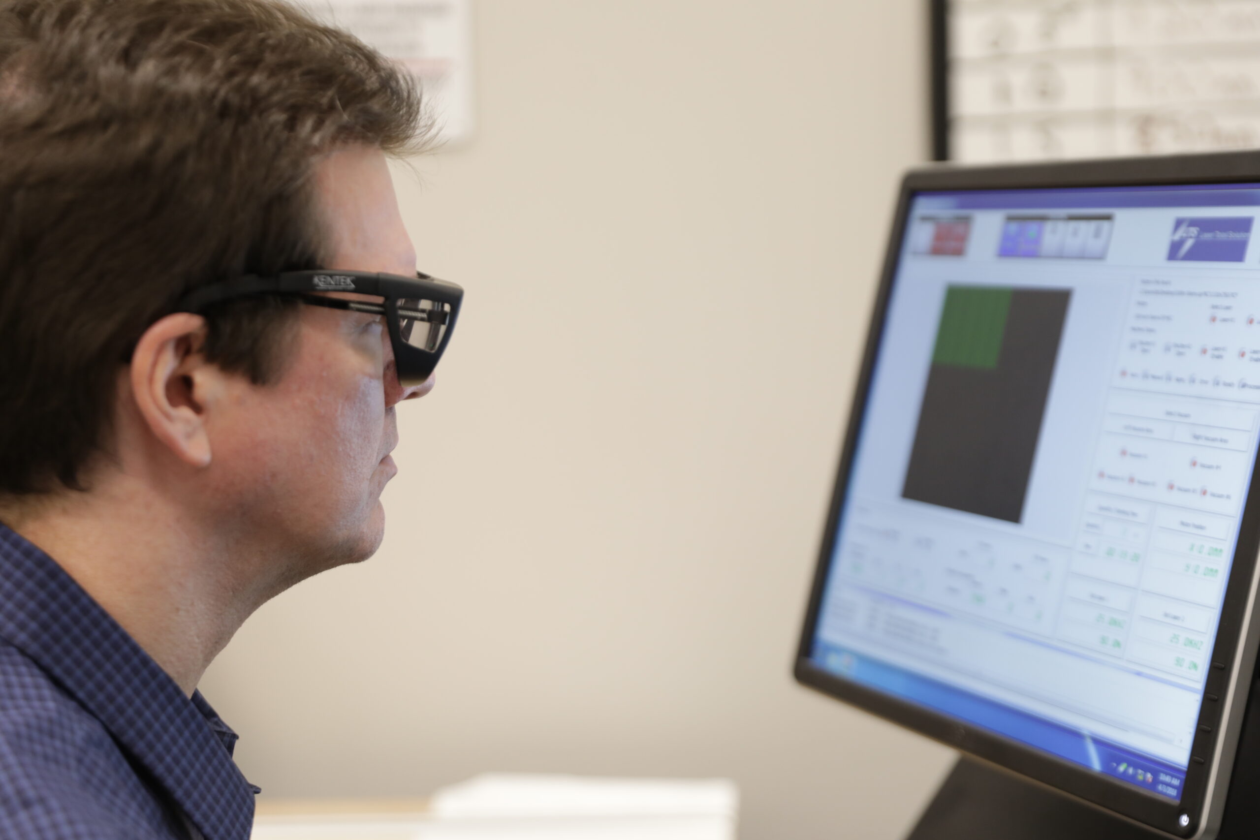 Engineer looks at computer screen while wearing glasses